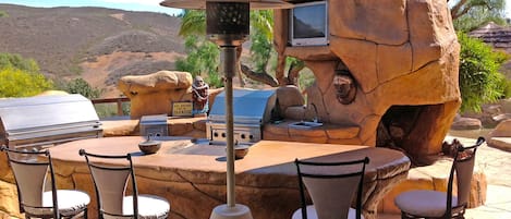 Outdoor kitchen and barbecue area with heat lamps for cool nights. 