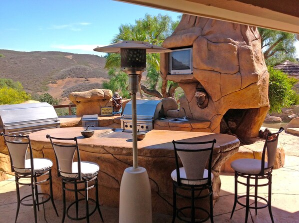 Outdoor kitchen and barbecue area with heat lamps for cool nights. 