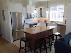 Cozy kitchen with 4 bar stools for additional seating. 