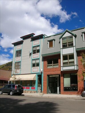 Front of building, 2 big south facing windows, one window is a bay window 