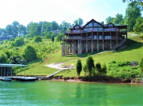 Rear of the home approaching from the lake.  The home sits on over an acre.