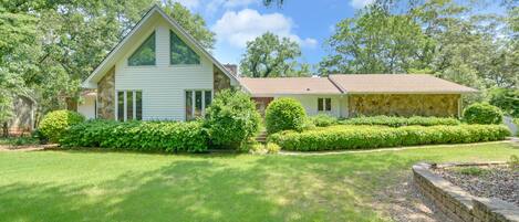 Beautiful front yard long tree lined driveway with a fenced yard
