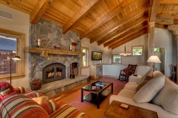 An open and airy living room filled with natural light, featuring a cozy wood-burning fireplace and a streaming-only TV for entertainment