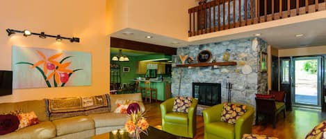 Ground floor living room with open floor plan and wood fireplace.