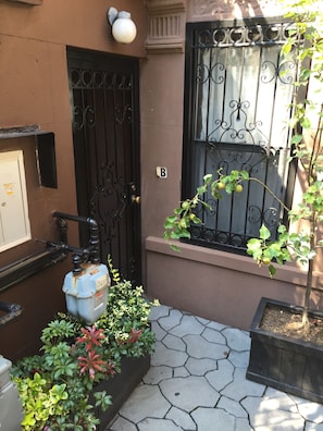 Garden apartment's private entrance with security gate.