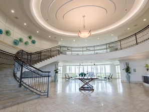 Grand entry with front desk on the right and sweeping stairway to the mezzanine 