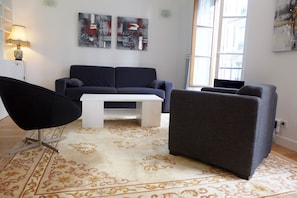 The living room offers a comfortable sofa & arm chairs