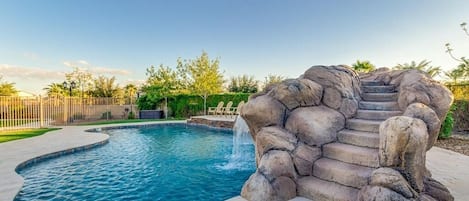 Heated pool with water slide and grotto. Approximately 9 ft deep.