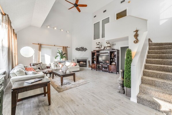 Large living room full of windows that looks out at the beach..