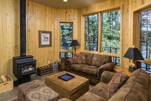 Living area with sweeping lake views, cozy wood stove.