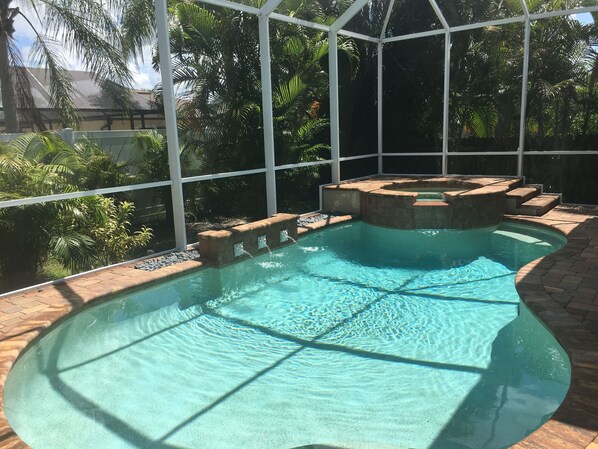 Spa with overflow into pool surrounded by high privacy fencing and new plantings