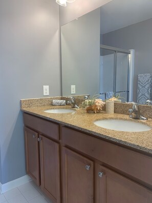 Full bathroom attached to upstairs suite with 2 sinks and a shower