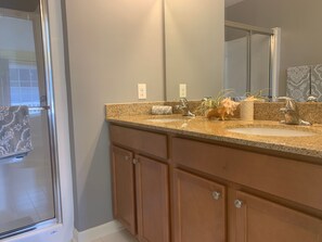 Full bathroom attached to upstairs suite with 2 sinks and a shower