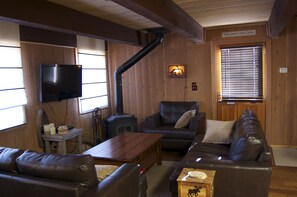 Living room. Couch, love seat and large comfy chair, wood burning stove, TV
