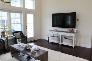 Great room with 70" 4K HD TV, door to screened in porch and deck