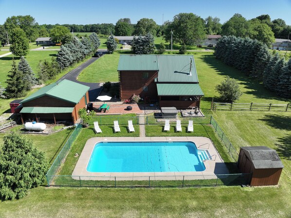  2 acres with large inground pool and hot tub; covered and screened back porch