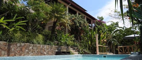 Pool, gardens and house on top of hill