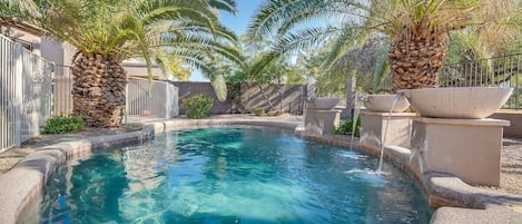 Enjoy swimming in the sparkling pool surrounded by palm trees and beautiful landscaping.