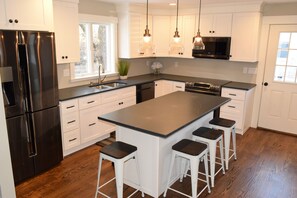 Gormet kitchen with slate counter tops with oversized island