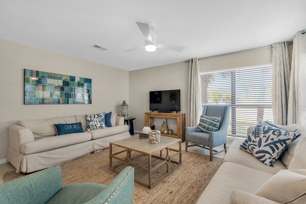 Large living room with flat screen TV and desk area