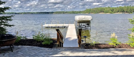 Lake view from lower patio. Firepit pit patio with chairs.