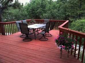 Relaxing deck, surrounded by trees.