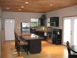 Kitchen area with granite tops, stainless steel applicances and bamboo floors