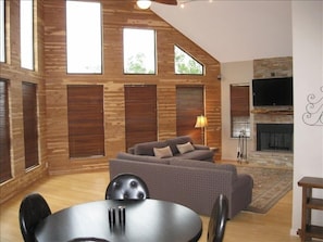 Open living room with stack stone fireplace,