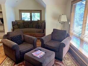 2 very comfortable armchairs, by windows and looking at TV, daybed in background