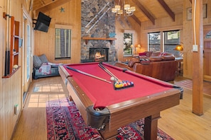 Great room with pool table, wood burning stove, sliders to outside deck.