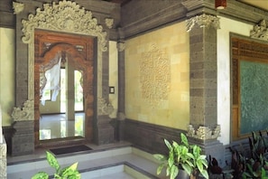 Extensive hand-carved wood and stone entry. Note the polished living room floor.