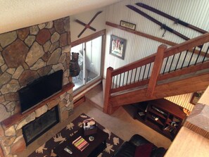 Brand new fireplace with mounted flat screen, stairs leading to loft