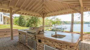 KitchenAid grill with side gas burner and sink in the covered outdoor kitchen.