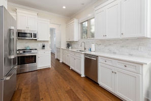 The Kitchen features stainless steel appliances and bright, white cabinets