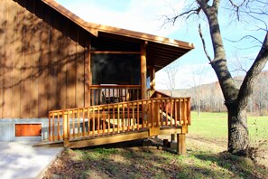 Ramp at back of cabin located on side with screened-in porch.