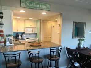 a nice view of the kitchen, breakfast bar and table.  and a buoy decoration