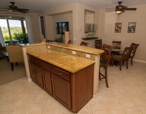 While cooking in the kitchen, family can be in the living room and dining room