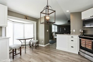 View of kitchen into great room with gas range and microwave