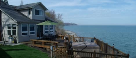 Two-tiered deck off of the main house with a hot tub 