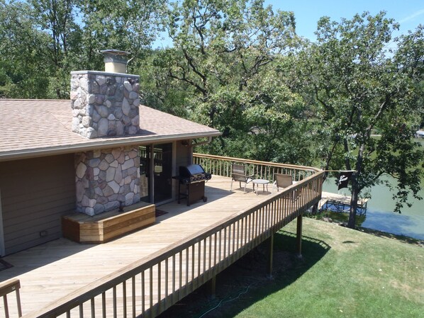 Birdseye view of the huge wrap around deck, front door, pier, and lake front