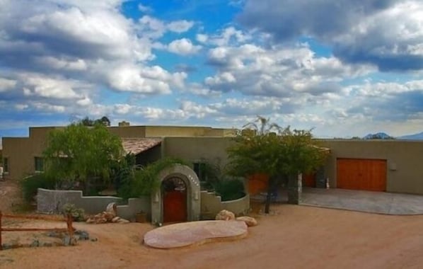 Photo looking south to driveway, garages and charming front entry