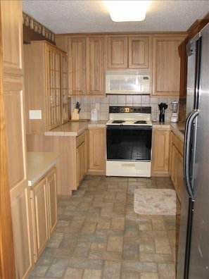 Completely furnished kitchen w/ tile floors and space to serve a large group.