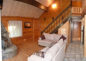 Cozy bright living room with 20 foot ceilings, warm wood stove