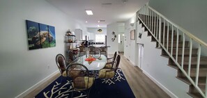 Open concept first floor with dining table for 6 and 3 bar stools at countertop.