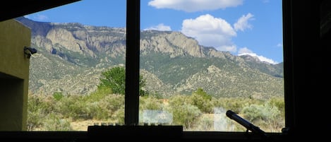 Large, trapezoid window in living room gives unobstructed view of Sandias.