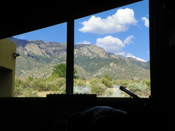 Large, trapezoid window in living room gives unobstructed view of Sandias.