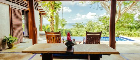 View from kitchen to outdoor dining, pool, ocean & jungle
