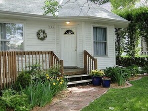 Close up of the front door, flower beds and brick sidewalk