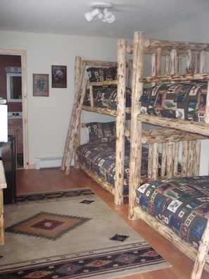 Room with two log bunk beds and bathroom.