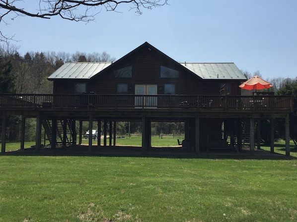 Large deck overlooks yard and river